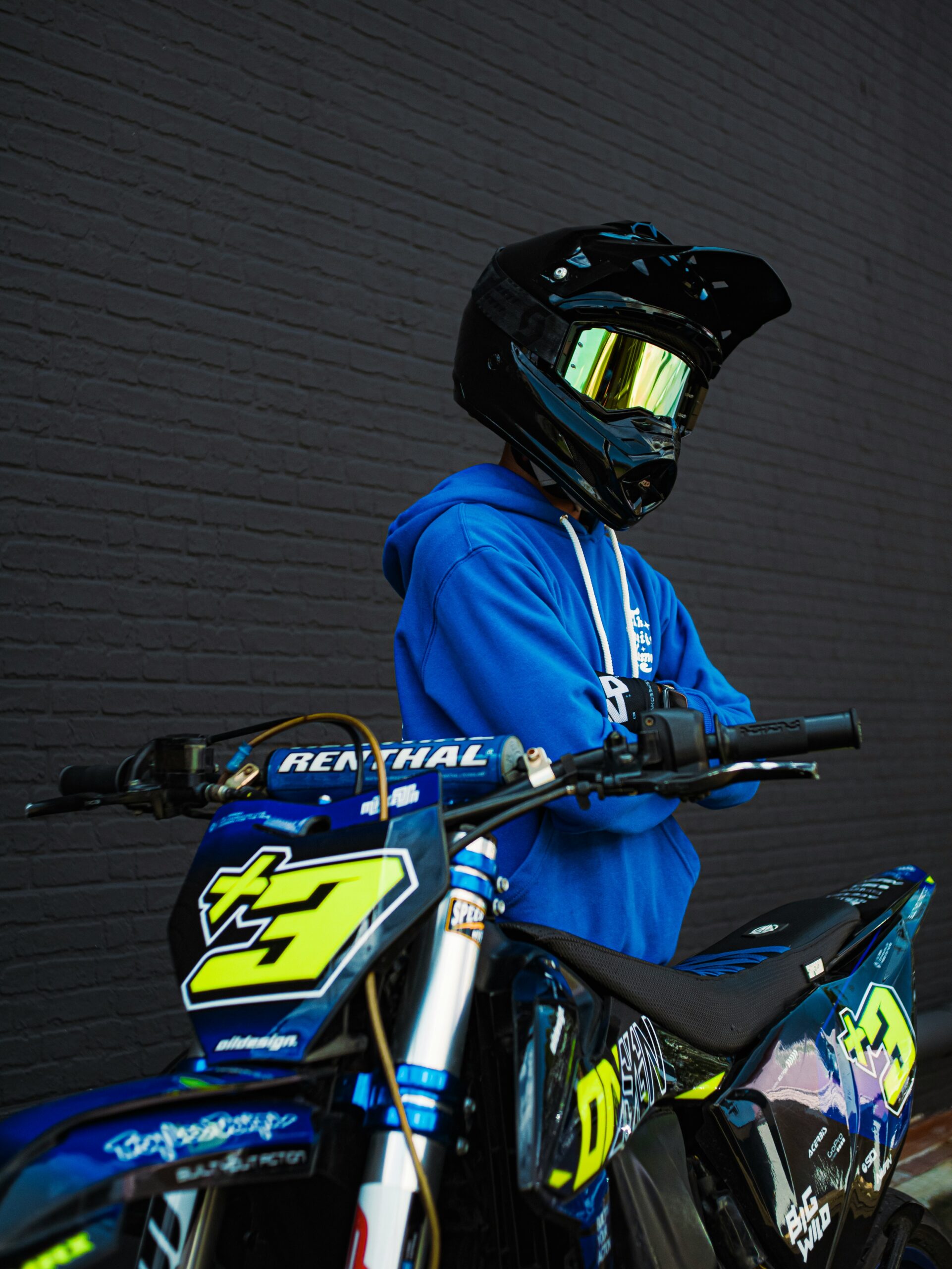 a person in a blue jacket and helmet on a dirt bike